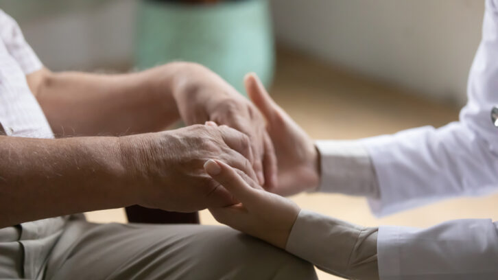 Caregiver holding senior's hands