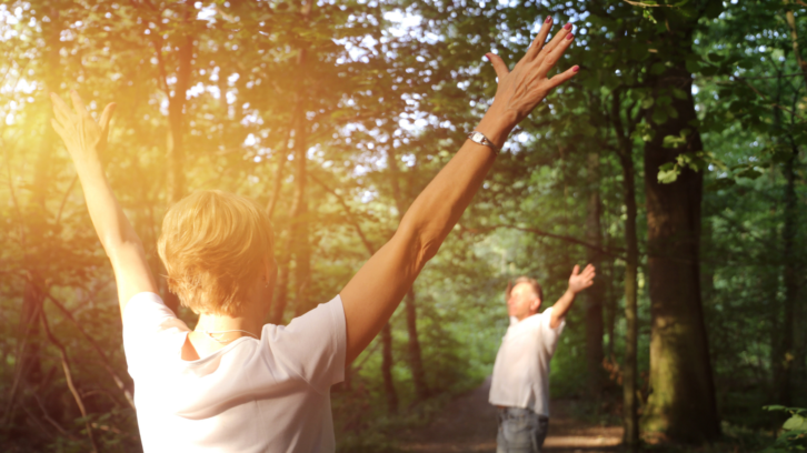 two people in forest with arms outstretched