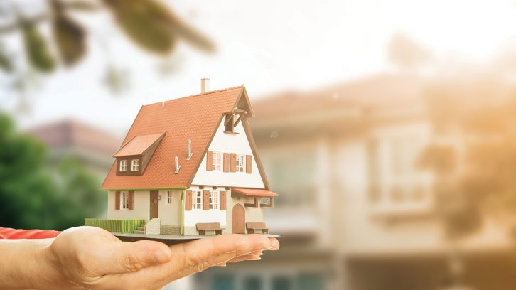 Woman's hand holding small model home