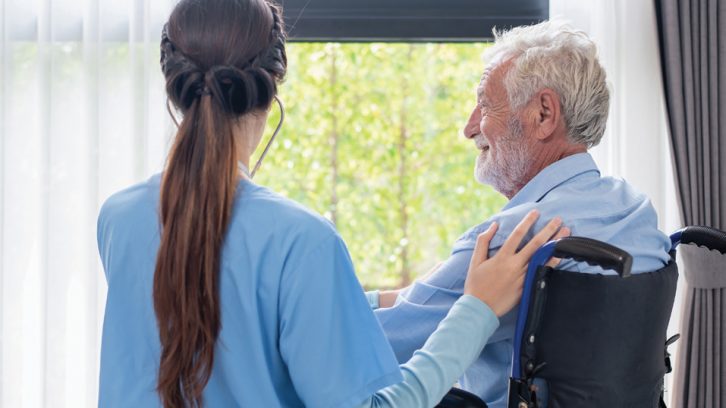 Health care worker caring for a senior in a wheelchair