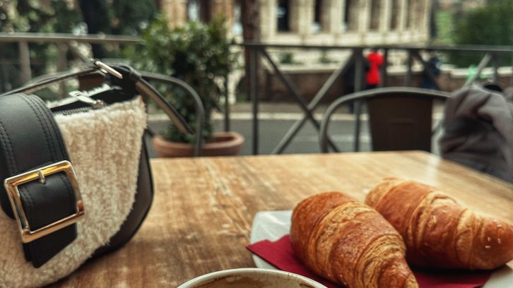 Coffee and croissant with view of the Colosseum in Rome