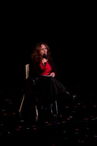 Woman sitting on a chair holding a microphone