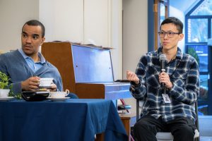 Man with a microphone talking to people having tea