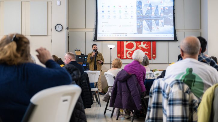 Group shot with a speaker talking to seated event attendees