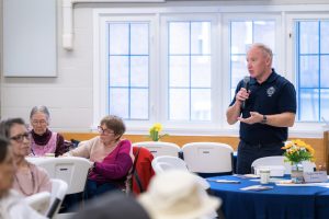 Person holding a microphone and speaking to event attendees
